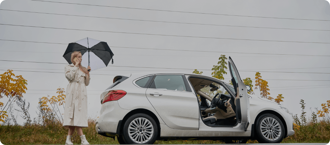 Driver beside a car during rainy weather